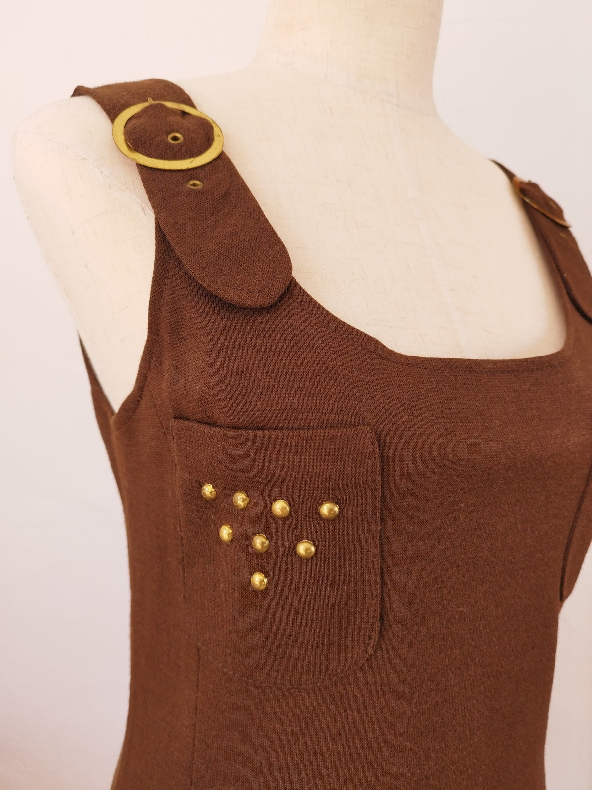 Vintage Brown Mini Dress with Straps and Brass Details Layered over a Blouse